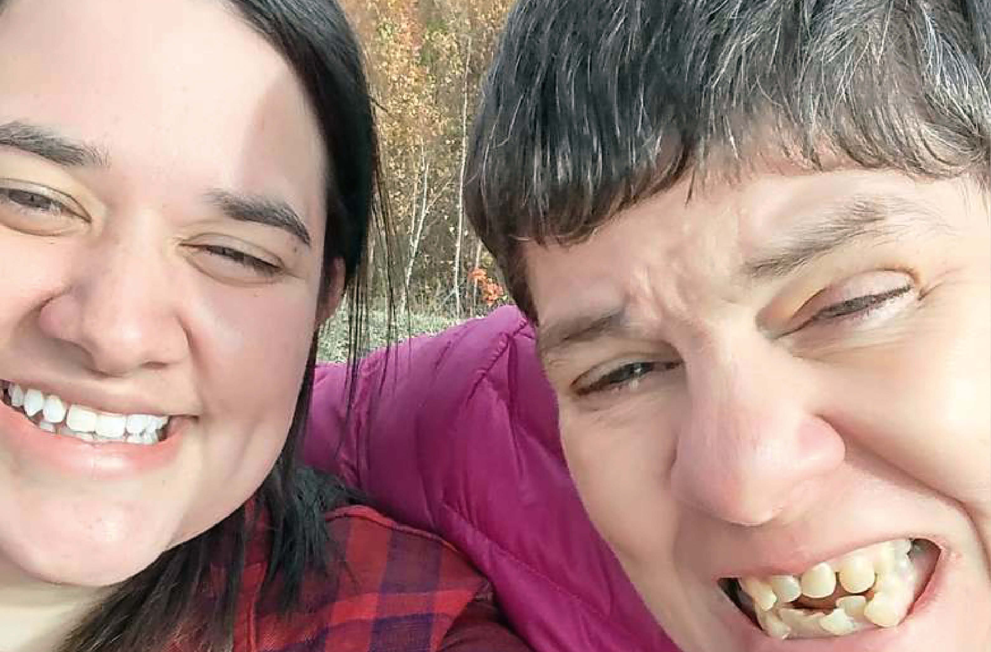 Zwei Frauen lachen in die Kamera und genießen einen sonnigen Tag im Freien. Im Hintergrund sind herbstlich gefärbte Bäume und ein ruhiger See zu sehen. Das Foto strahlt Freude und Freundschaft aus. Zwei Frauen lachen in die Kamera und genießen einen sonnigen Tag im Freien. Im Hintergrund sind herbstlich gefärbte Bäume und ein ruhiger See zu sehen. Das Foto strahlt Freude und Freundschaft aus.