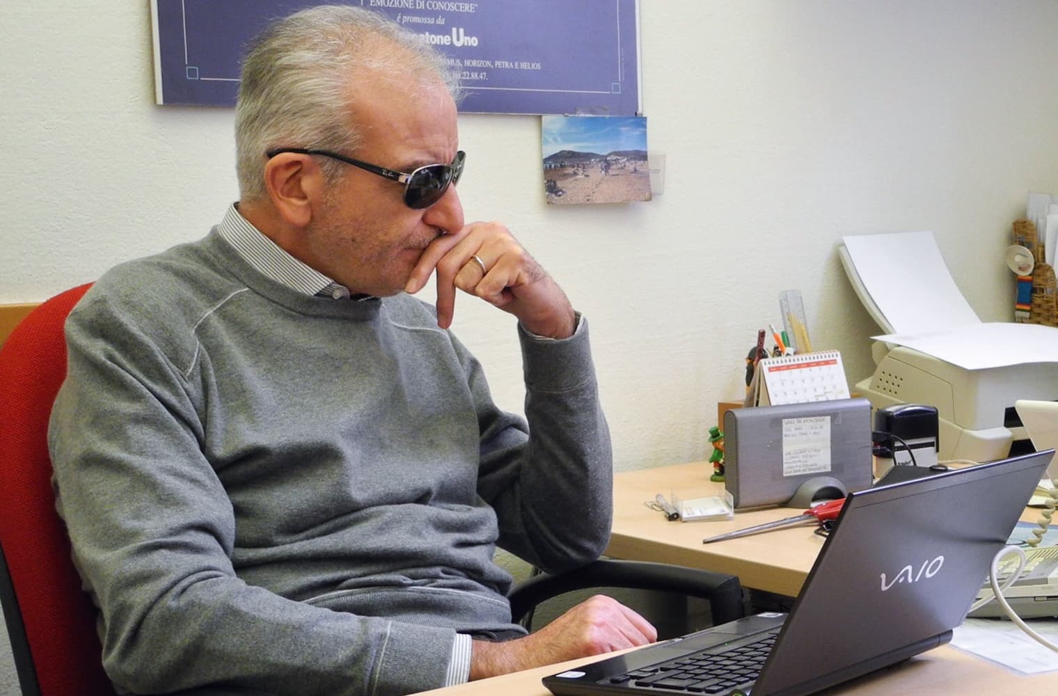 Prof. Nicola Cuomo mit dunkler Brille sitzt vor dem Laptop und überlegt angestrengt. Foto Stefan Meyer