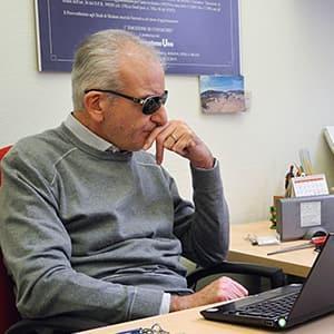 Prof. Nicola Cuomo mit dunkler Brille sitzt vor dem Laptop und überlegt angestrengt. Foto Stefan Meyer